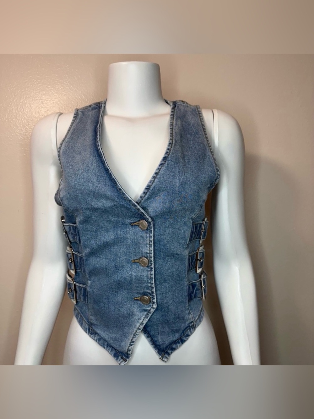 Light blue denim vest with buckle details on the sides